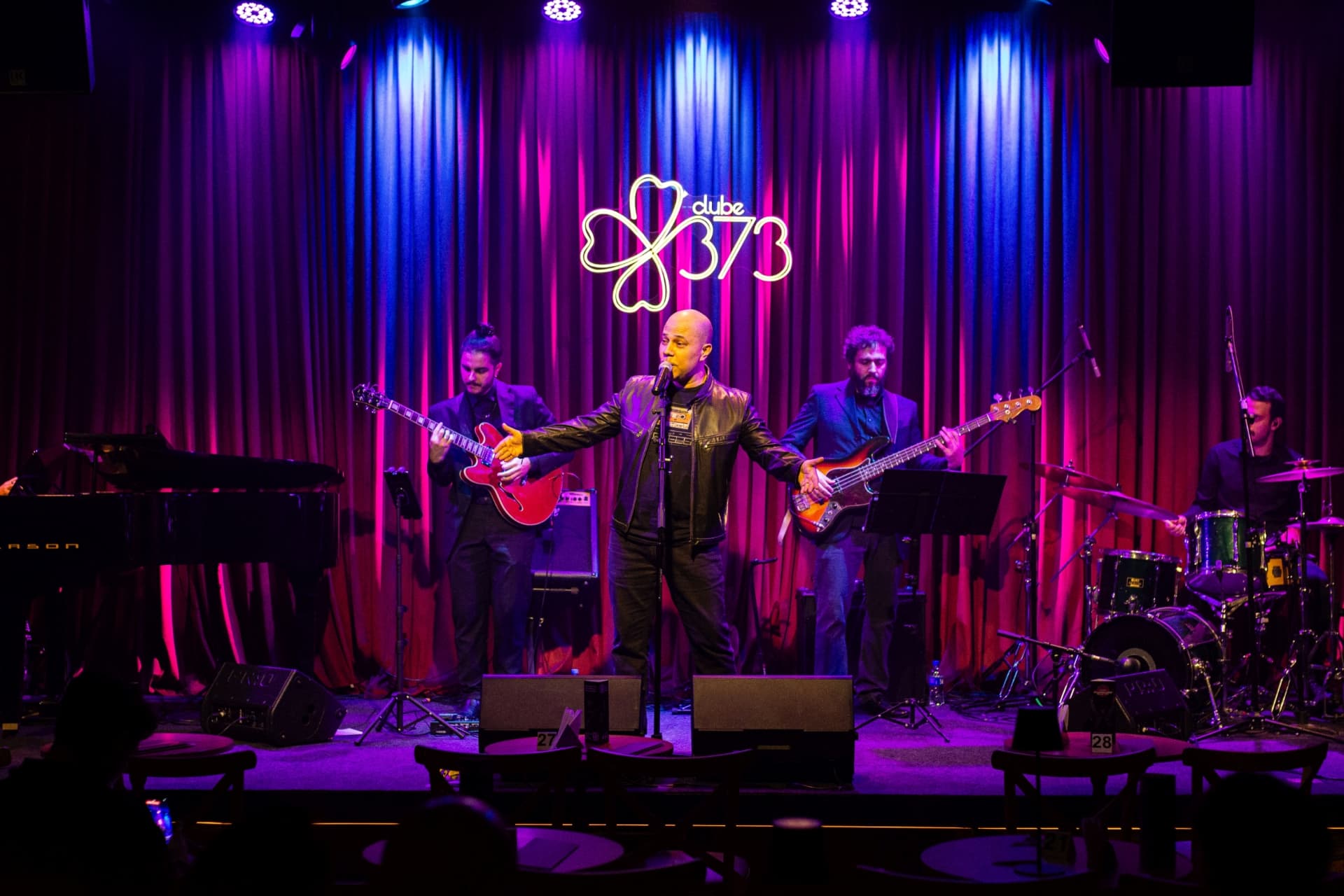 Arno Duarte cantando com a banda no palco do Clube 373